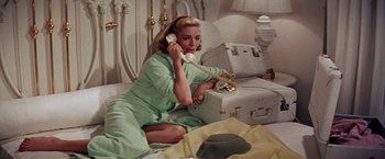 Movie still from “Designing Woman” (1957), directed by Vincente Minnelli – A woman sitting on the ground talking on a phone; Medium shot, High angle
