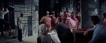 Movie still from “Designing Woman” (1957), directed by Vincente Minnelli – A group of people dressed in pink and white; Wide shot, Low angle