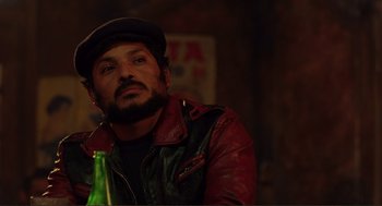 Movie still from “Desperado” (1995), directed by Robert Rodriguez – A man with a beard and a hat is holding a beer; Close Up shot, Over the shoulder angle