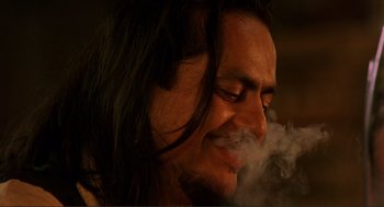 Movie still from “Desperado” (1995), directed by Robert Rodriguez – A person with long hair smoking; Close Up shot, Low angle