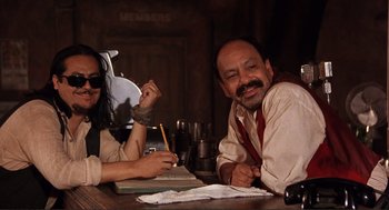 Movie still from “Desperado” (1995), directed by Robert Rodriguez – A man and a woman sitting at a table; Medium shot, Low angle