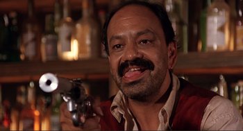 Movie still from “Desperado” (1995), directed by Robert Rodriguez – A man with a mustache holding a gun in his hand; Close Up shot, Low angle