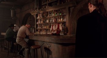 Movie still from “Desperado” (1995), directed by Robert Rodriguez – A man standing at the bar of a bar; Wide shot, Low angle