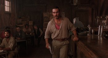 Movie still from “Desperado” (1995), directed by Robert Rodriguez – A man standing in a room holding a wii controller; Medium shot, Low angle
