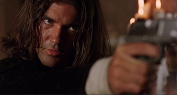 Movie still from “Desperado” (1995), directed by Robert Rodriguez – A person holding a gun; Close Up shot, Low angle