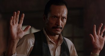 Movie still from “Desperado” (1995), directed by Robert Rodriguez – A person wearing a shirt and vest; Close Up shot, Low angle