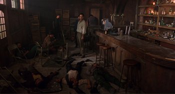 Movie still from “Desperado” (1995), directed by Robert Rodriguez – A group of people in a room next to a bar; Wide shot, High angle