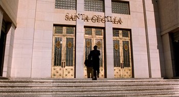 Movie still from “Desperado” (1995), directed by Robert Rodriguez – A person walking up steps in front of a building; Extreme Wide shot, Low angle
