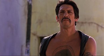 Movie still from “Desperado” (1995), directed by Robert Rodriguez – A person with a tattoo on his chest; Close Up shot, Low angle