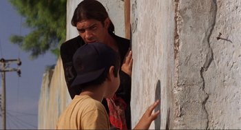 Movie still from “Desperado” (1995), directed by Robert Rodriguez – A young man and a young boy standing next to each other; Medium shot, Over the shoulder angle