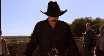 Movie still from “Desperado” (1995), directed by Robert Rodriguez – A man in a black cowboy hat holding a gun; Medium shot, Low angle