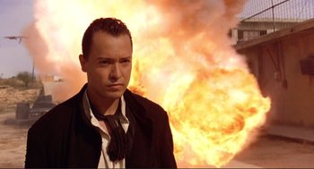 Movie still from “Desperado” (1995), directed by Robert Rodriguez – A man standing in front of a burning building; Close Up shot, Low angle
