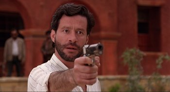 Movie still from “Desperado” (1995), directed by Robert Rodriguez – A person holding a gun; Close Up shot, Over the shoulder angle