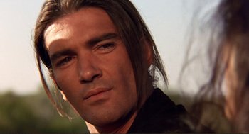 Movie still from “Desperado” (1995), directed by Robert Rodriguez – A man with long hair is looking at the camera; Close Up shot, Low angle