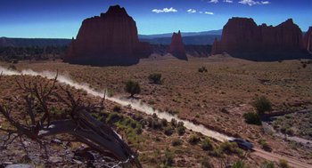Movie still from “Desperate Hours” (1990), directed by Michael Cimino – A dirt road in the middle of the desert; Extreme Wide shot, High angle