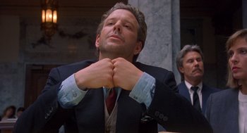 Movie still from “Desperate Hours” (1990), directed by Michael Cimino – A man that is sitting in front of a wall; Medium shot, Low angle