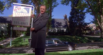 Movie still from “Desperate Hours” (1990), directed by Michael Cimino – A man holding a sign in front of a car; Wide shot, Low angle