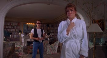 Movie still from “Desperate Hours” (1990), directed by Michael Cimino – A man and a woman standing in a living room; Medium shot, Over the shoulder angle