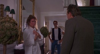 Movie still from “Desperate Hours” (1990), directed by Michael Cimino – A group of people standing around in a room; Medium shot, Over the shoulder angle