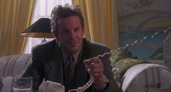 Movie still from “Desperate Hours” (1990), directed by Michael Cimino – A man in a suit and tie holding a phone; Close Up shot, Low angle