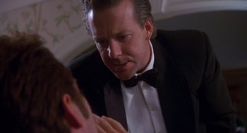 Movie still from “Desperate Hours” (1990), directed by Michael Cimino – A man in a tuxedo looking at another man in a suit; Close Up shot, Over the shoulder angle