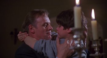 Movie still from “Desperate Hours” (1990), directed by Michael Cimino – An older man holding a young boy in his arms; Close Up shot, Over the shoulder angle