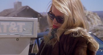 Movie still from “Desperate Hours” (1990), directed by Michael Cimino – A woman in sunglasses talking on a phone; Close Up shot, High angle