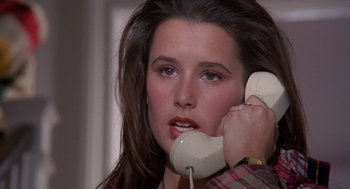 Movie still from “Desperate Hours” (1990), directed by Michael Cimino – A woman holding a phone up to her ear; Close Up shot, High angle