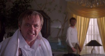 Movie still from “Desperate Hours” (1990), directed by Michael Cimino – A man in a white dress shirt and tie with another man behind him; Close Up shot, Low angle