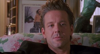 Movie still from “Desperate Hours” (1990), directed by Michael Cimino – A person sitting on a couch in a living room; Close Up shot, Over the shoulder angle