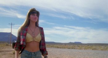 Movie still from “Desperate Hours” (1990), directed by Michael Cimino – A woman in a plaid shirt and a yellow bra; Medium shot, Low angle