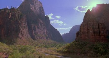 Movie still from “Desperate Hours” (1990), directed by Michael Cimino – A view of a valley with mountains in the background; Extreme Wide shot, High angle