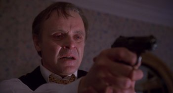 Movie still from “Desperate Hours” (1990), directed by Michael Cimino – An old man with a sad look on his face holding a cell phone; Close Up shot, Low angle