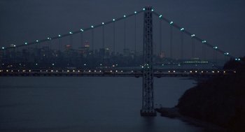 Movie still from “Desperately Seeking Susan” (1985), directed by Susan Seidelman – A view of a bridge lit up at night; Extreme Wide shot, High angle