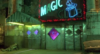 Movie still from “Desperately Seeking Susan” (1985), directed by Susan Seidelman – A neon sign on the side of a building lit up at night; Wide shot, Low angle
