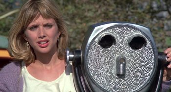 Movie still from “Desperately Seeking Susan” (1985), directed by Susan Seidelman – A woman standing next to a coin machine; Close Up shot, Over the shoulder angle