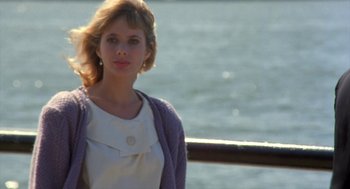 Movie still from “Desperately Seeking Susan” (1985), directed by Susan Seidelman – A woman standing next to a body of water; Close Up shot, Over the shoulder angle