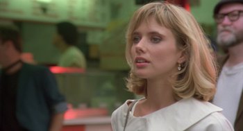 Movie still from “Desperately Seeking Susan” (1985), directed by Susan Seidelman – A woman with blonde hair wearing a white dress; Close Up shot, Over the shoulder angle