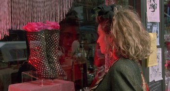 Movie still from “Desperately Seeking Susan” (1985), directed by Susan Seidelman – A woman looking at a pair of boots in a store window; Close Up shot, Over the shoulder angle