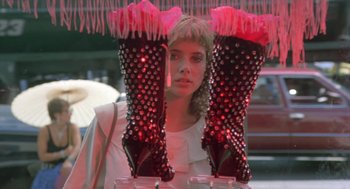 Movie still from “Desperately Seeking Susan” (1985), directed by Susan Seidelman – A woman standing in front of a pair of pink spiked boots; Close Up shot, Low angle