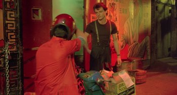 Movie still from “Desperately Seeking Susan” (1985), directed by Susan Seidelman – A man in black shirt standing next to a man in black shirt; Medium shot, Over the shoulder angle