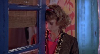 Movie still from “Desperately Seeking Susan” (1985), directed by Susan Seidelman – A woman standing in front of a window; Close Up shot, High angle