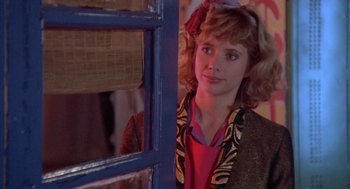Movie still from “Desperately Seeking Susan” (1985), directed by Susan Seidelman – A woman standing in front of a window; Close Up shot, Over the shoulder angle