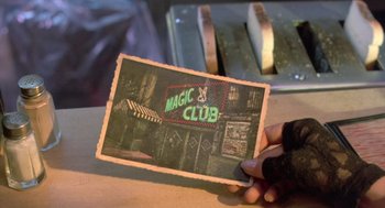 Movie still from “Desperately Seeking Susan” (1985), directed by Susan Seidelman – Someone is holding up an old photo of a club; Extreme Close Up shot, High angle