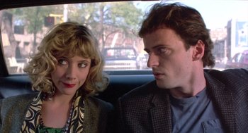 Movie still from “Desperately Seeking Susan” (1985), directed by Susan Seidelman – A man and a woman sitting in the back of a car; Close Up shot, Over the shoulder angle