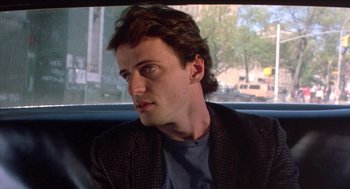 Movie still from “Desperately Seeking Susan” (1985), directed by Susan Seidelman – A man sitting in the back seat of a car; Close Up shot, Over the shoulder angle