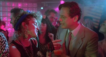 Movie still from “Desperately Seeking Susan” (1985), directed by Susan Seidelman – A man and a woman talking to each other at a party; Close Up shot, Over the shoulder angle