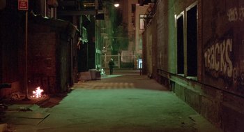 Movie still from “Desperately Seeking Susan” (1985), directed by Susan Seidelman – A person is walking down a dark alley way at night; Extreme Wide shot, High angle