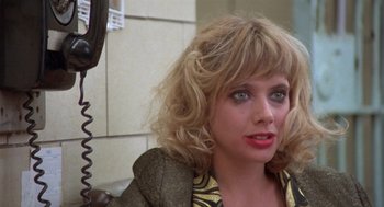 Movie still from “Desperately Seeking Susan” (1985), directed by Susan Seidelman – A person sitting on a chair; Close Up shot, Over the shoulder angle