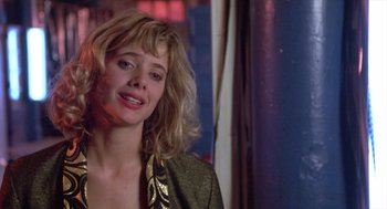 Movie still from “Desperately Seeking Susan” (1985), directed by Susan Seidelman – A person wearing a suit and tie; Close Up shot, Over the shoulder angle